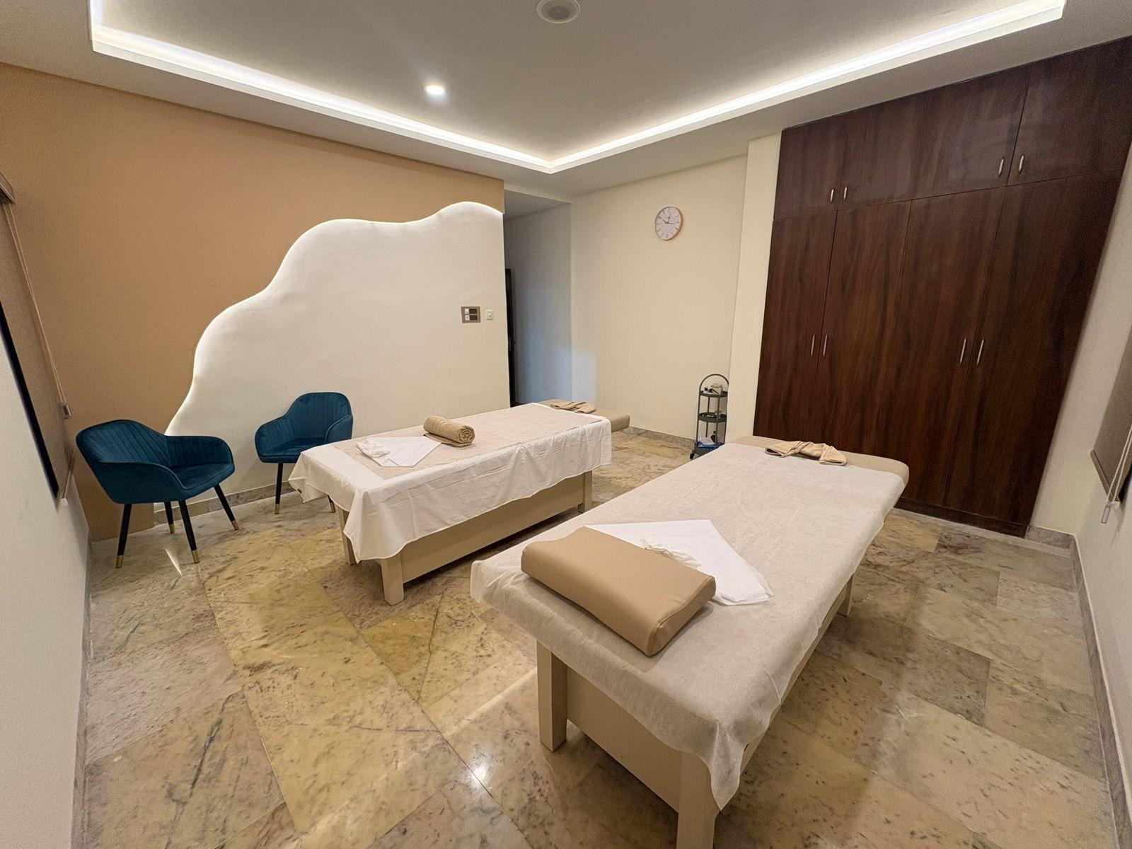 Couple massage room at Soulscape Elite with a sculpted plaster wave wall lit from behind
